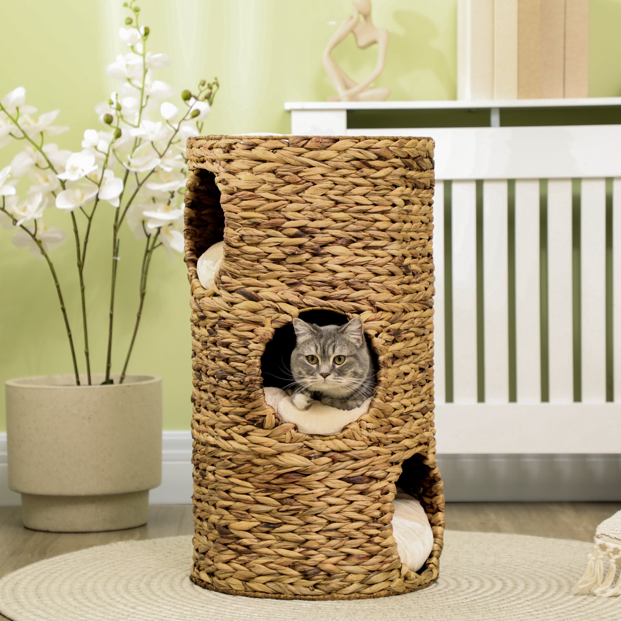 En elegant trevånings klöstunna för katt tillverkad av naturlig flätad vattenhyacint med mjuka liggplatser.