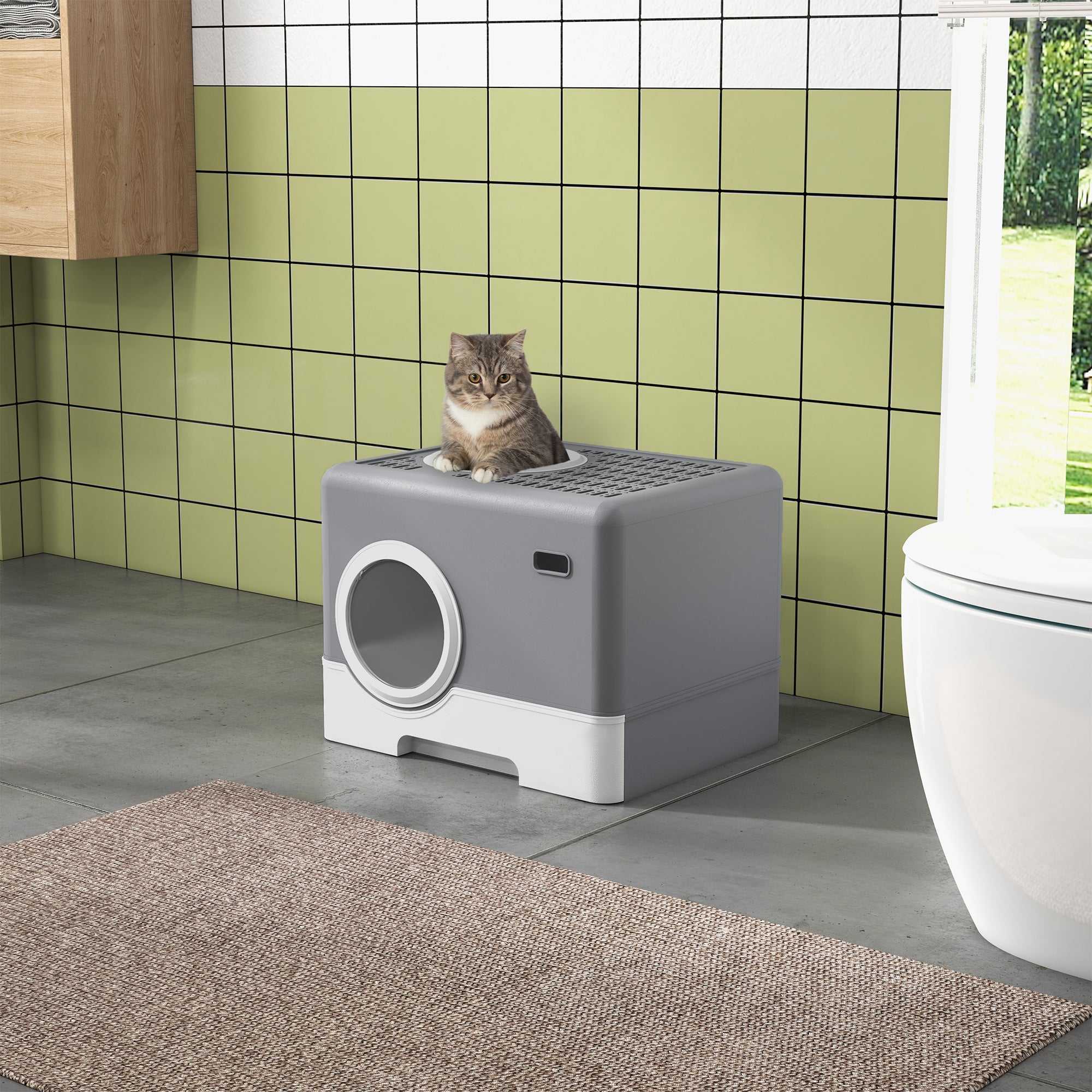 En rymlig och diskret grå kattlåda placerad i ett badrum, med en katt som vilar på det gallerförsedda taket.