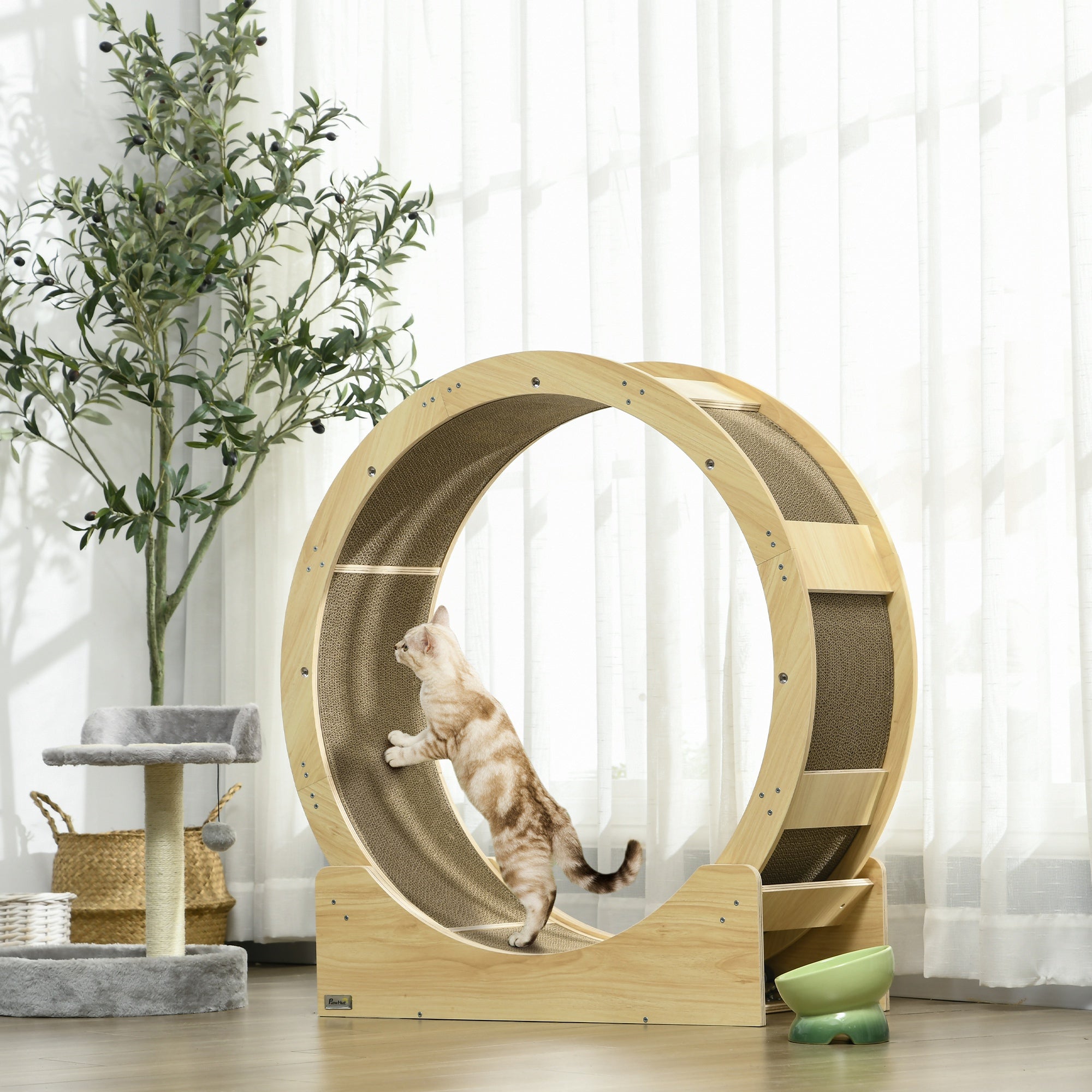 En katt springer i ett stort elegant kattrullhjul i ekfinish med inbyggd klösmatta, placerat i ett vardagsrum.