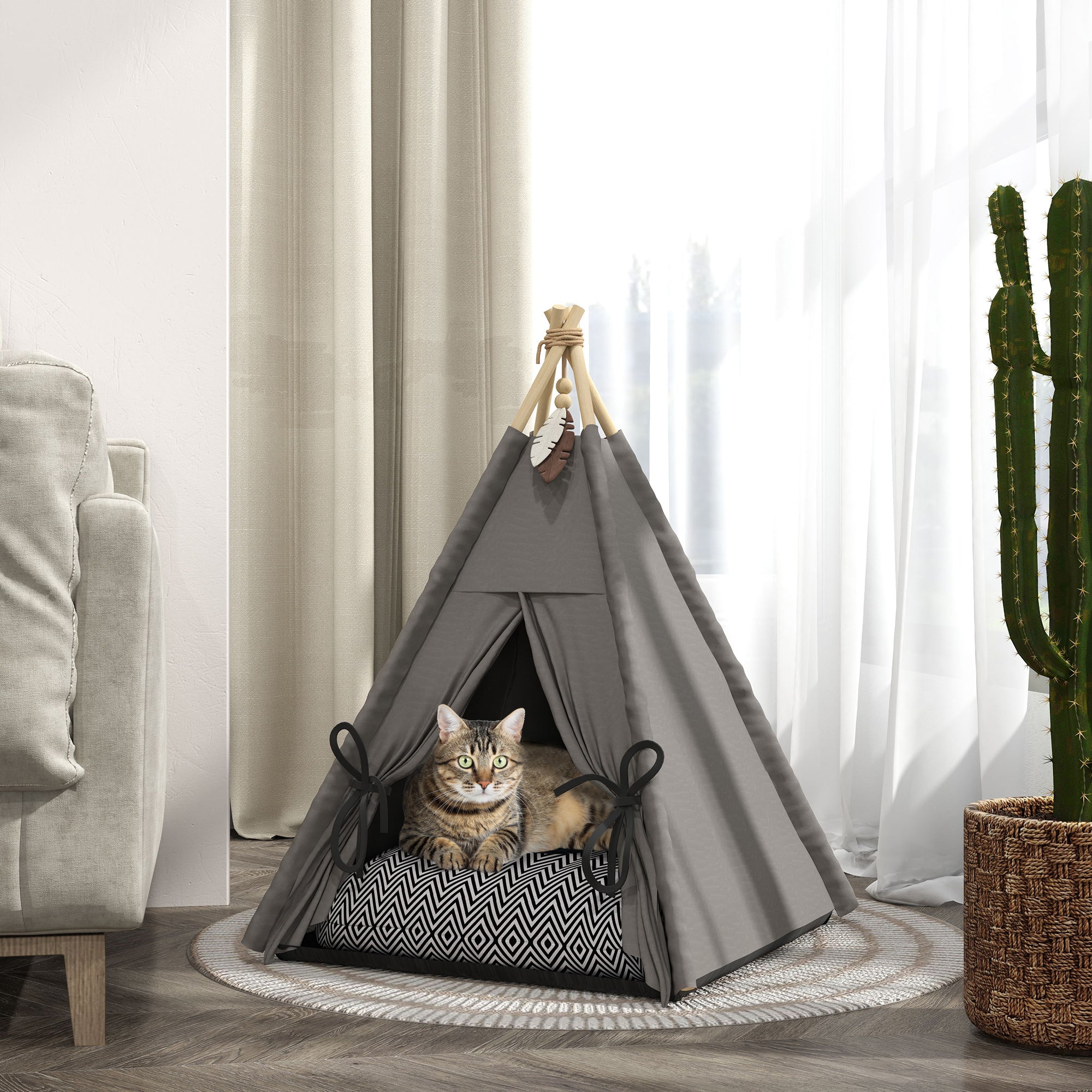 En katt vilar inuti ett elegant grått tipi-tält för husdjur, utrustat med en mjuk kudde och placerat i ett ljust vardagsrum.
