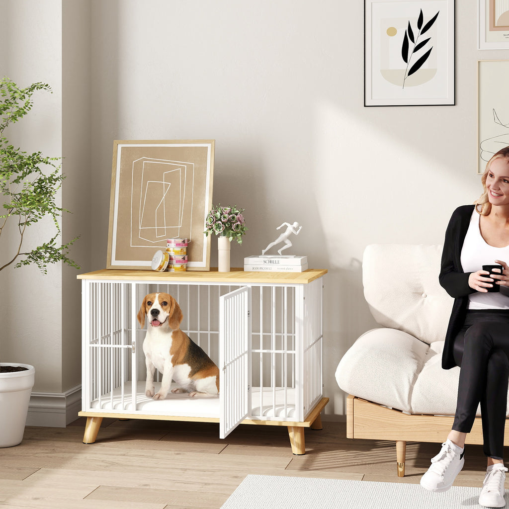 Stilren hundbur i vit och ek möbeldesign placerad i ett vardagsrum med en hund inuti