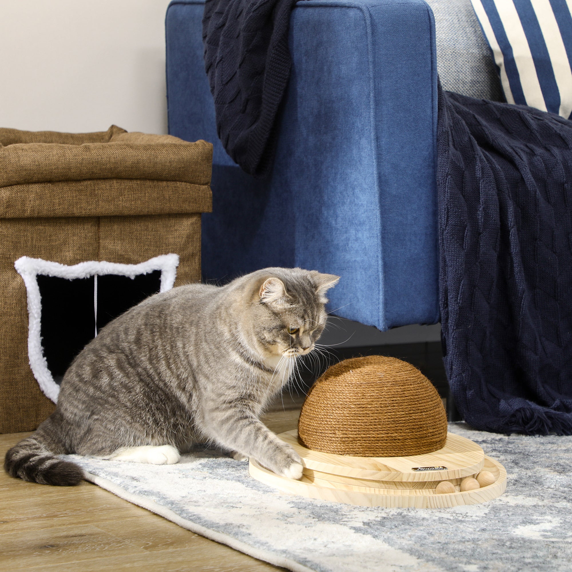 Elegant interaktiv kattleksak i furu och jute med en oval klösyta i mitten och en kulbana som stimulerar kattens lekfullhet.