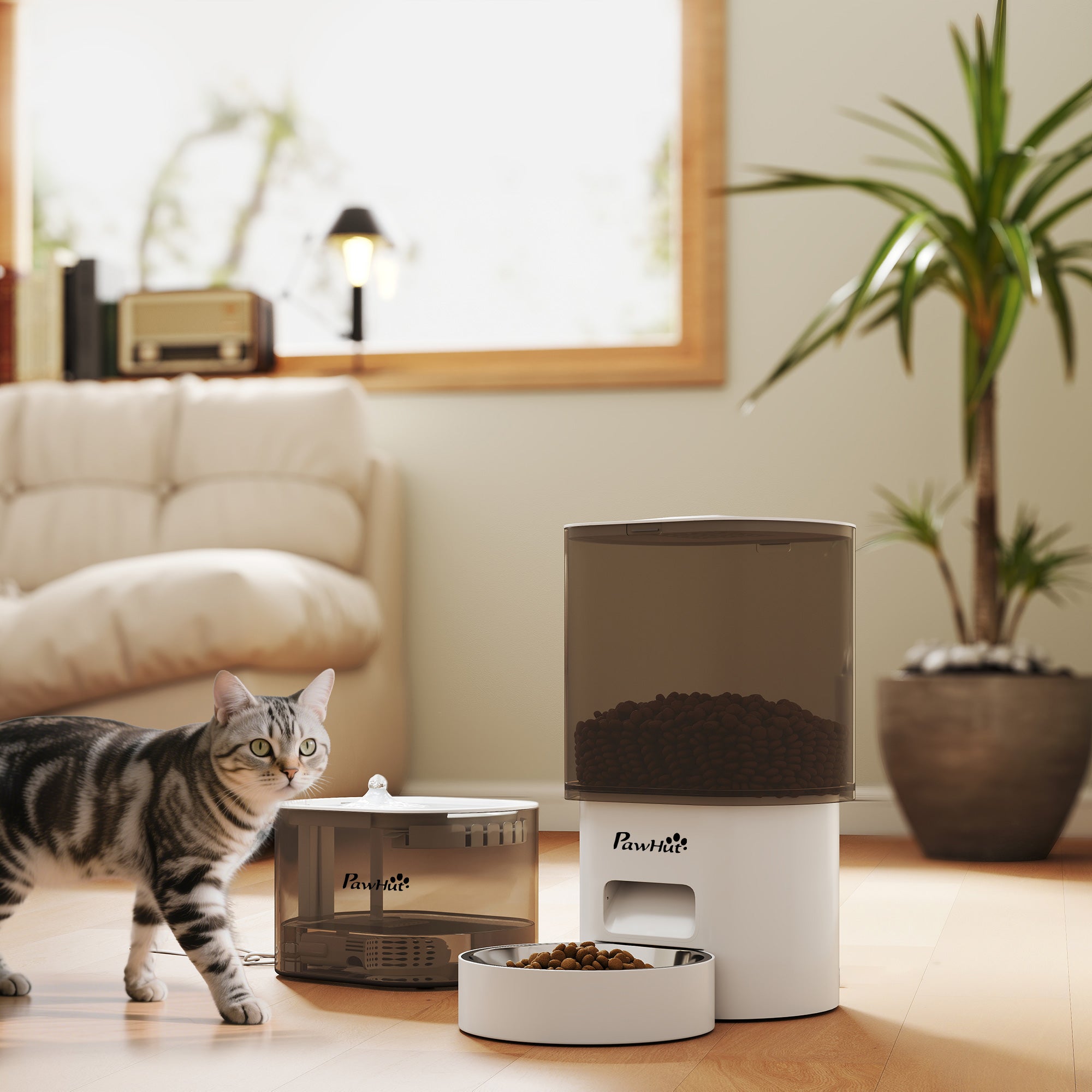 En intelligent vit foderautomat och vattenfontän i ett set, placerad i ett vardagsrum med en katt som äter.