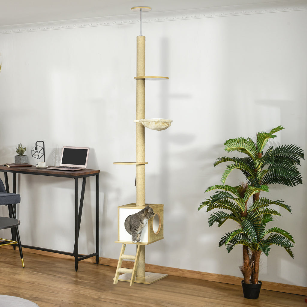 Ett elegant takhögt klösträd (240-260 cm) i ljusbrun design med hus, hängmatta och klätterstege placerat i ett vardagsrum.