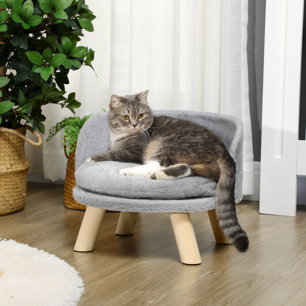 En elegant upphöjd djurbädd i grått med mjuka kanter och en fluffig tvättbar dyna, där en katt vilar bekvämt.